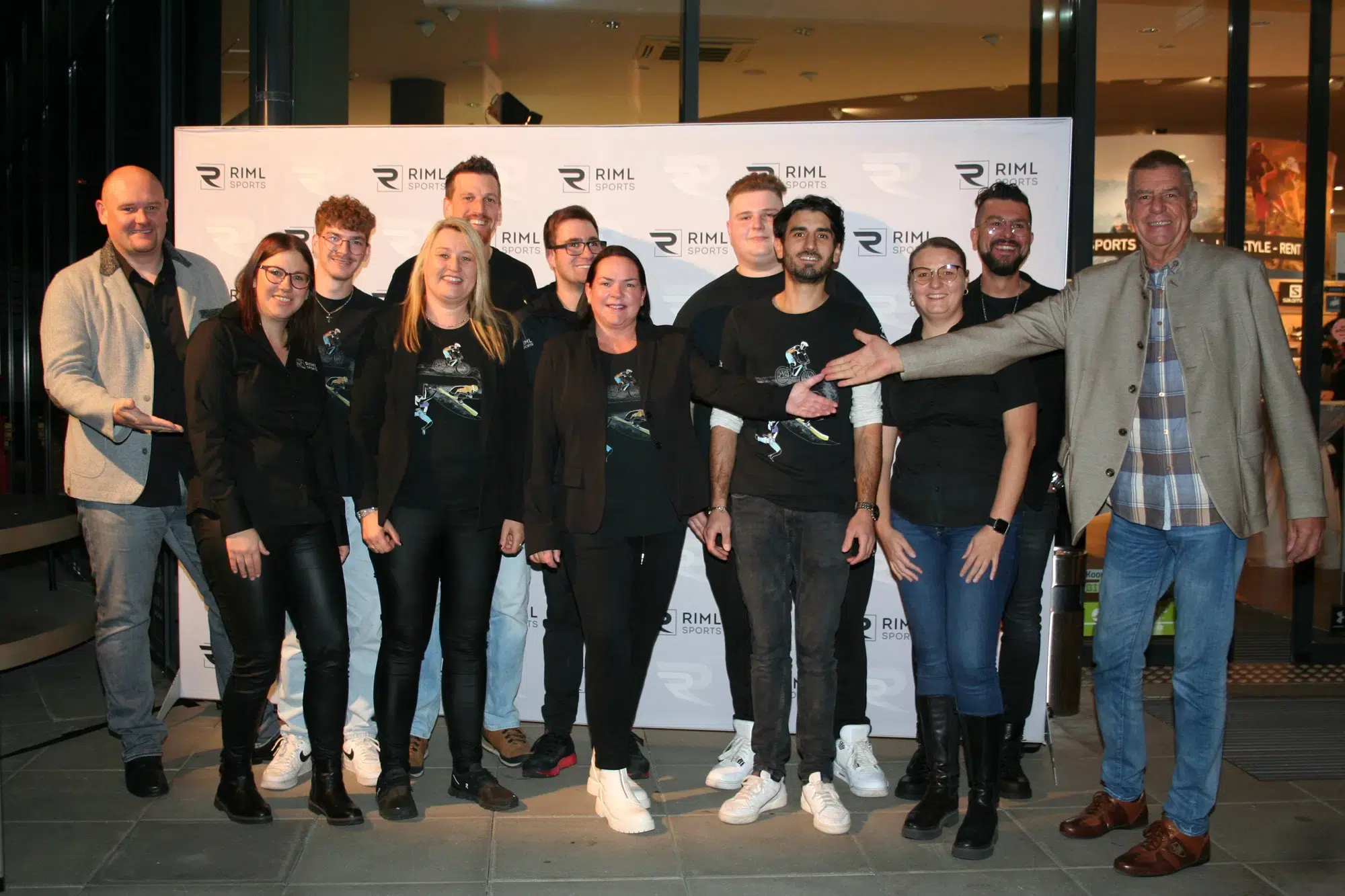 Eine Gruppe von Menschen, die lächelnd vor einer Ötztaler RIML-Kulisse posieren.