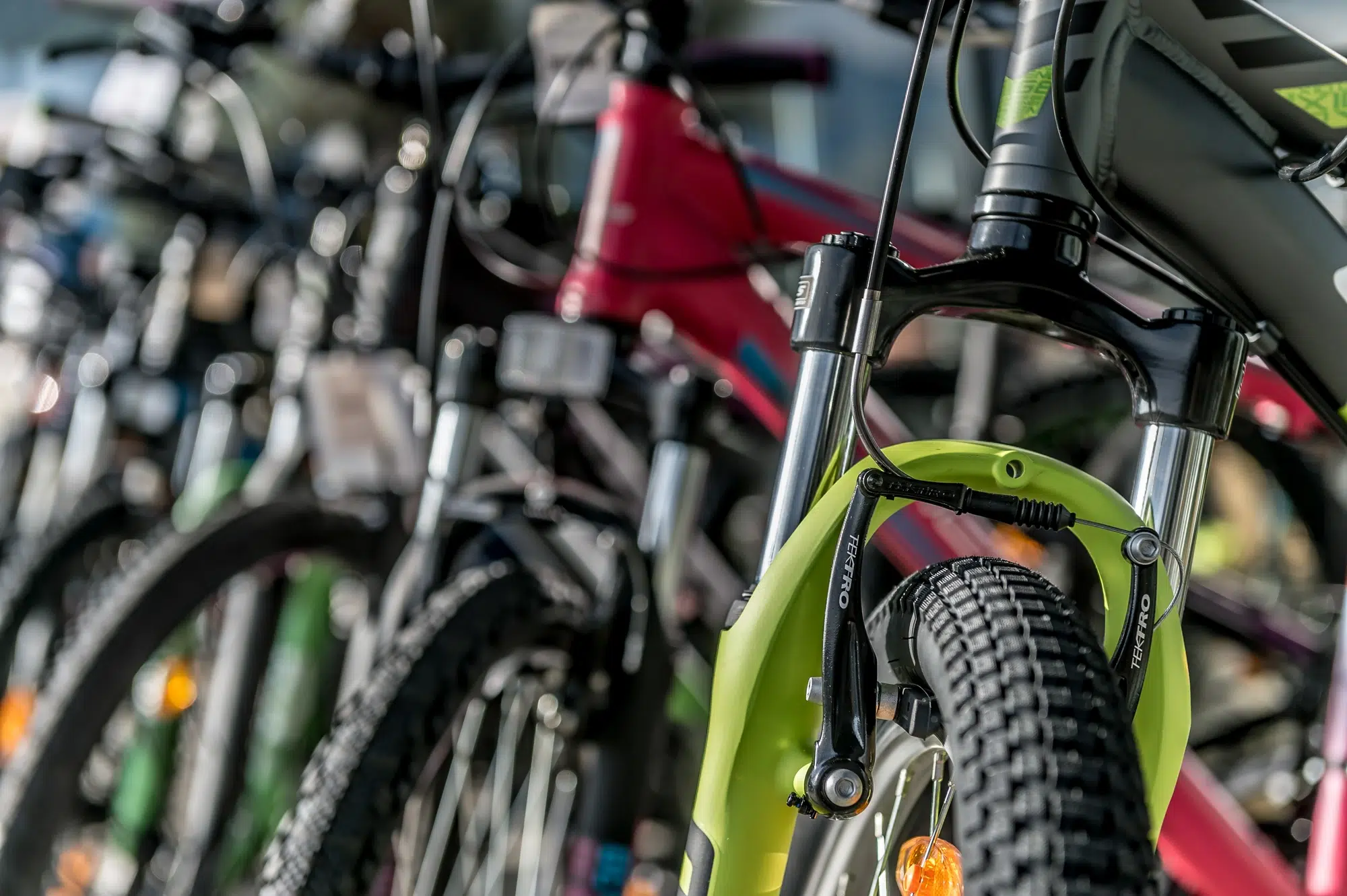Nahaufnahme von mehreren im Ötztal abgestellten Fahrrädern, wobei der Schwerpunkt auf dem Vorderrad und der Gabel liegt.