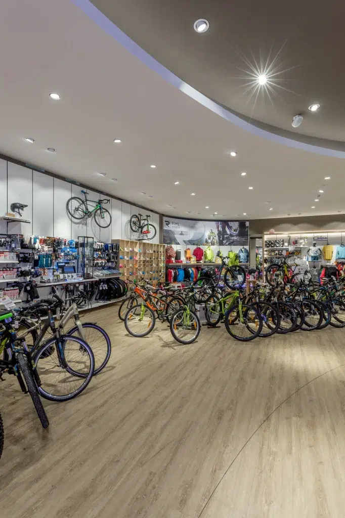 Modernes Fahrradgeschäft mit Ötztaler Fahrrädern, Helmen und Ausrüstung, die auf Holzböden ausgestellt sind.