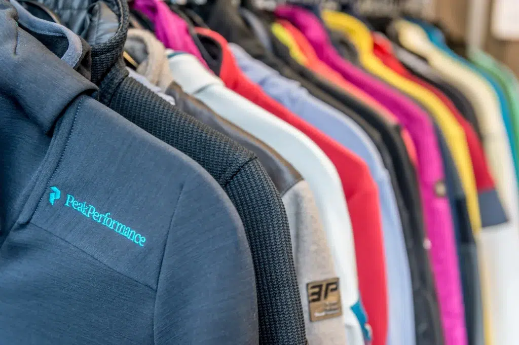 Eine Reihe bunter Jacken hängt auf einem Gestell, auf einigen Ärmeln sind Ötztal-Logos zu sehen.