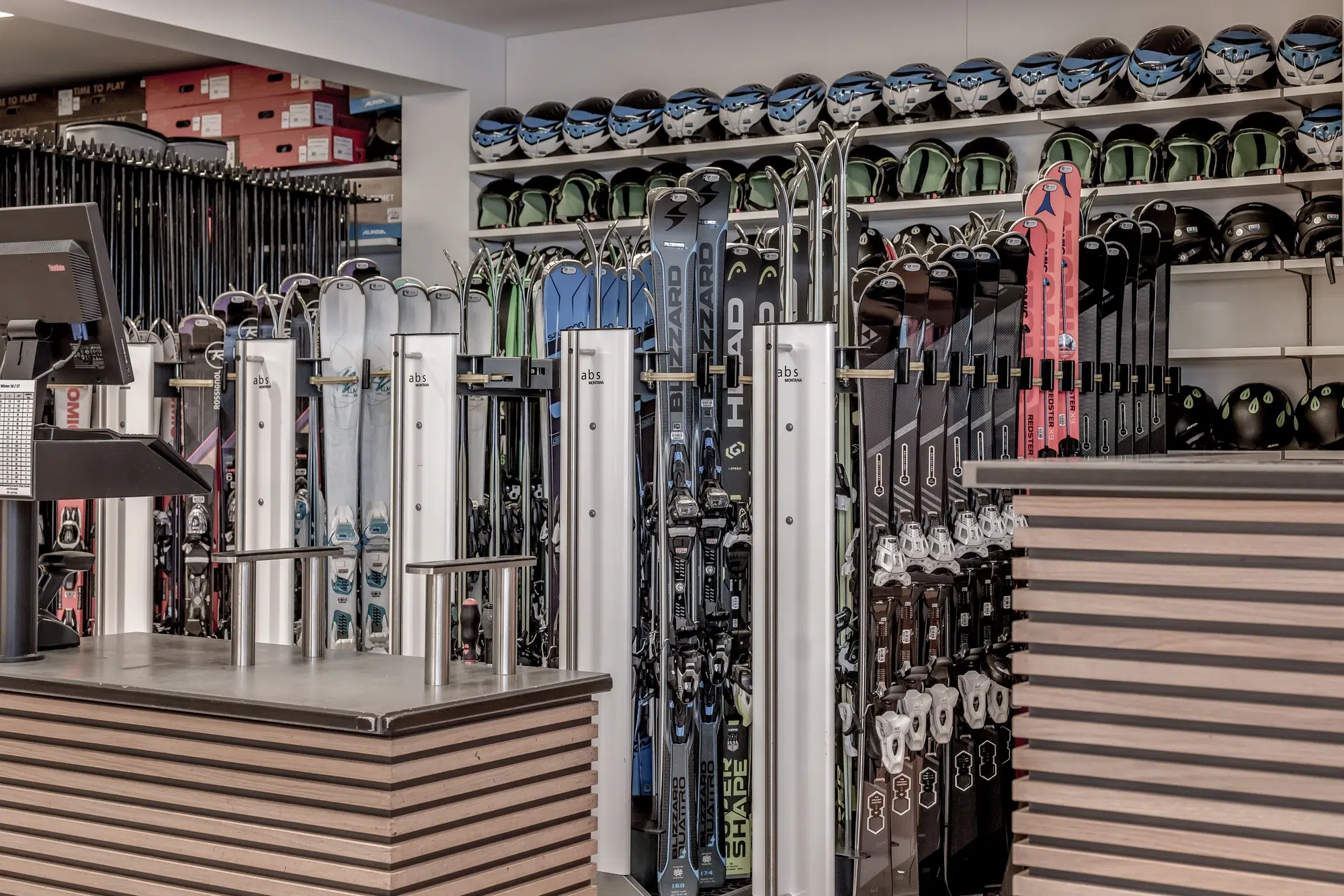 Skigeschäft im Ötztal mit Regalen mit Skiern, Helmen und Skistöcken in der Auslage.