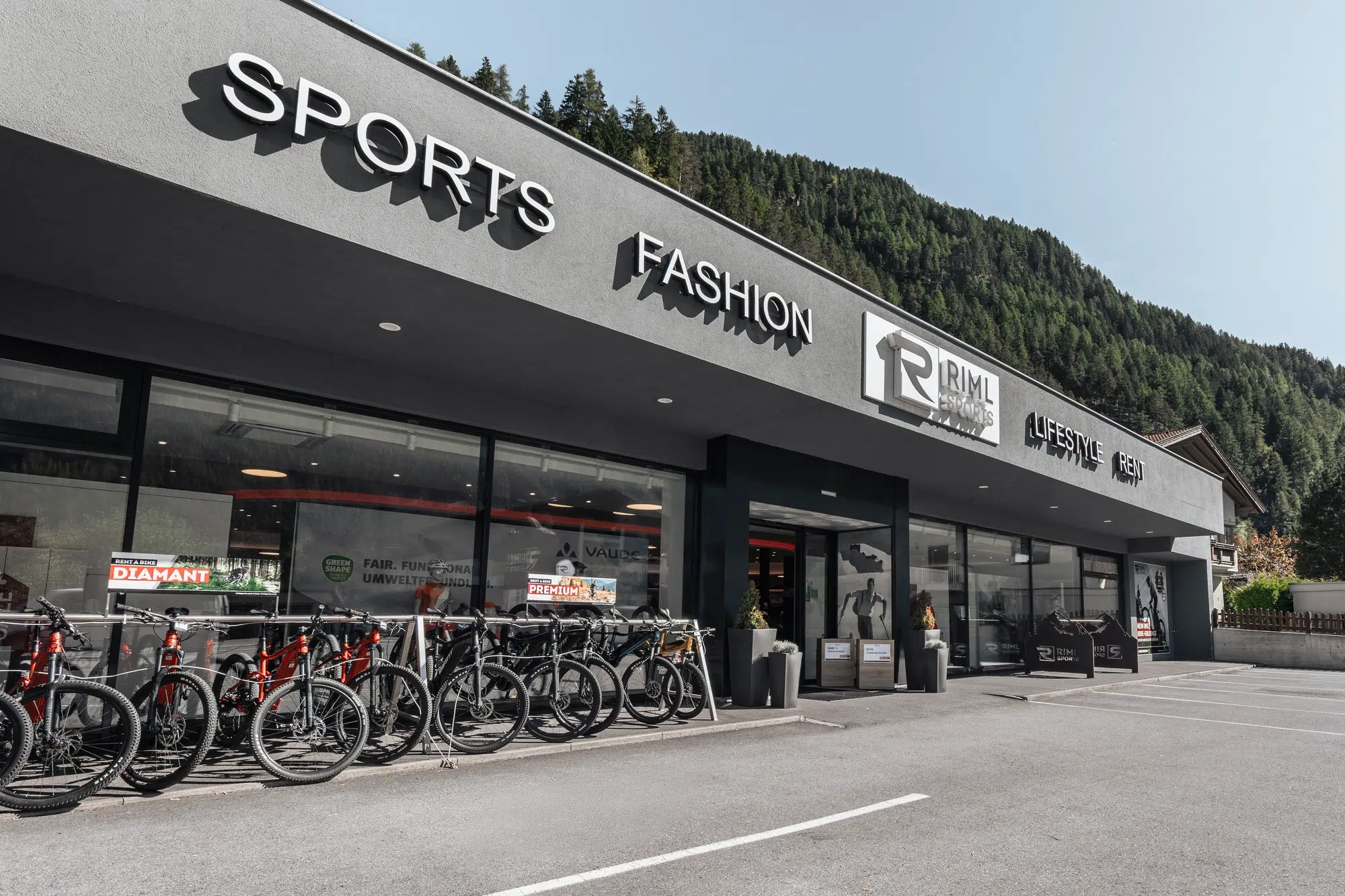 Vor einem modernen Sport- und Modegeschäft in den malerischen Ötztaler Bergen sind Fahrräder aufgereiht.