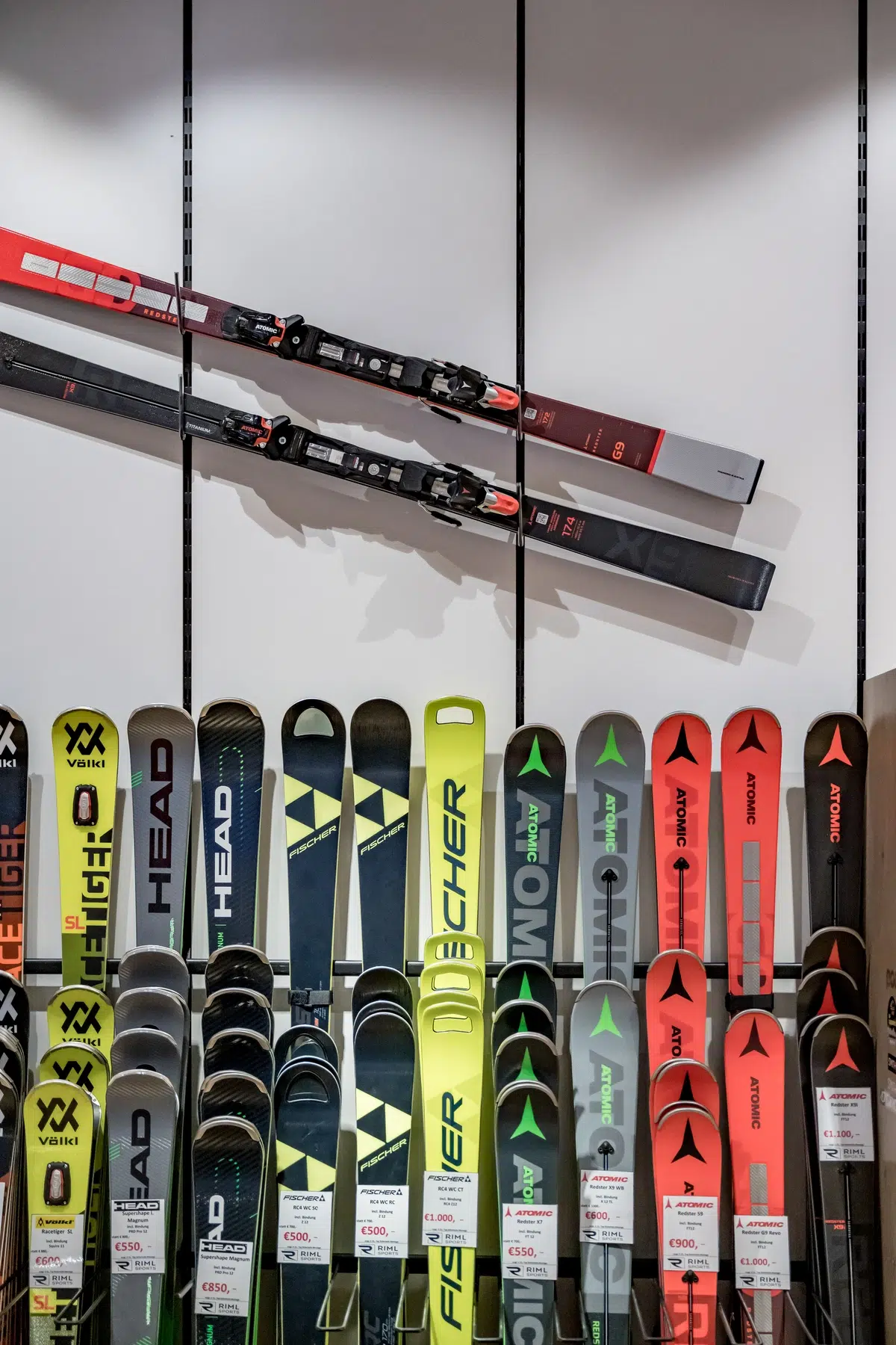Verschiedene Skimarken, darunter auch Ötztal, sind vertikal ausgestellt, zwei davon sind an der Wand befestigt.