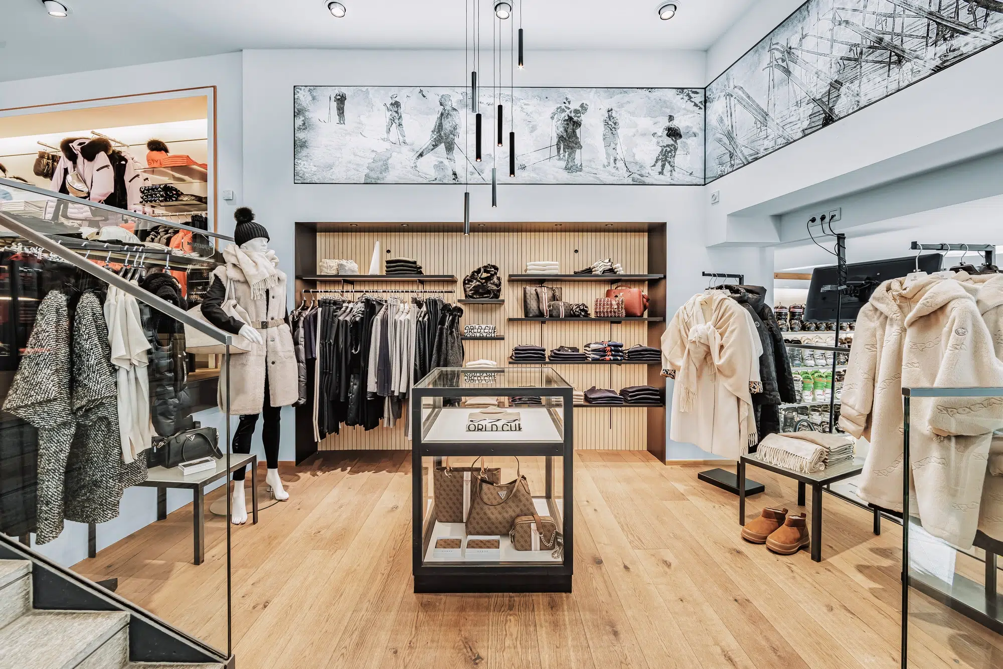 Modernes Ötztaler Bekleidungsgeschäft mit ordentlich ausgestellter Kleidung, Accessoires und einer Vitrine.