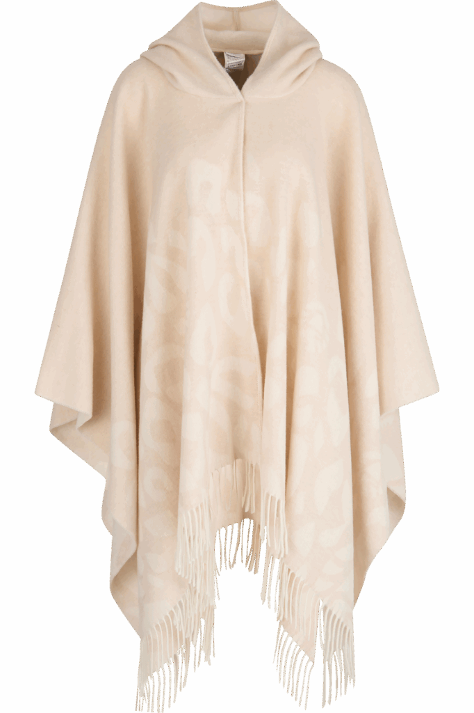 Beigefarbener Kapuzenponcho mit dezentem, vom Ötztal inspiriertem Muster und Fransen am Saum.