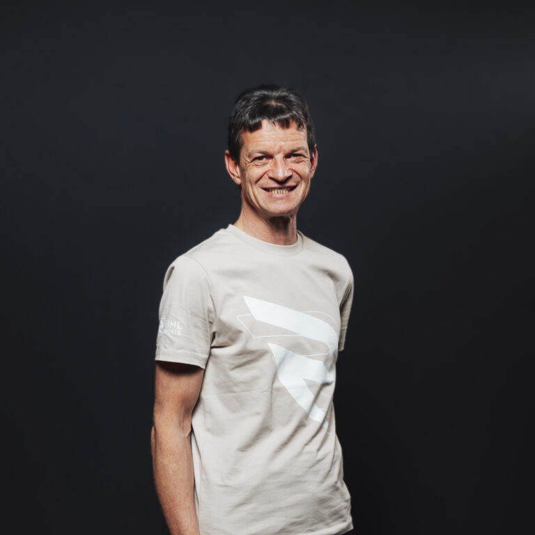 Mann in hellem T-Shirt, stehend und lächelnd, bereit für Jobs & Teamangebote.