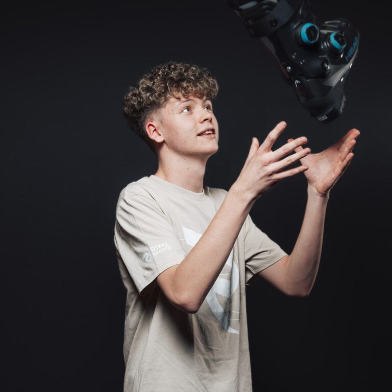 Ein junger Mensch aus unserem Jobs & Team wirft ein Virtual-Reality-Headset in die Luft, dunkler Hintergrund.