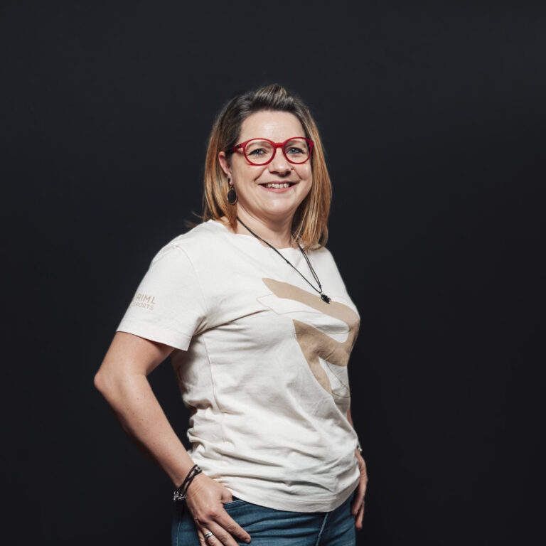 Frau mit roter Brille und weißem T-Shirt, lächelnd - perfekt für Jobs & Team-Profile.
