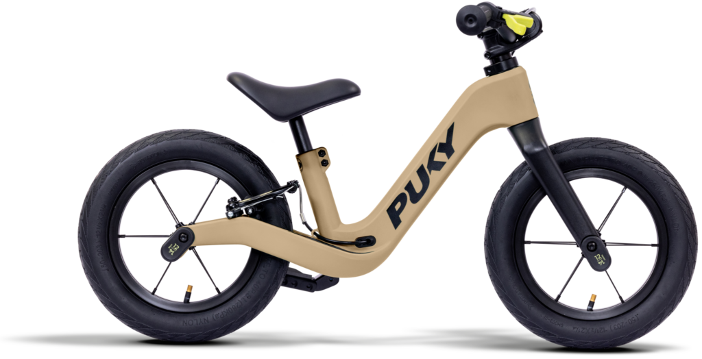 Beigefarbenes PUKY Balance-Bike mit schwarzen Rädern und Sitz, von der Seite gesehen.